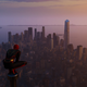 Spider-Man surveys Manhattan from a perch above a building at dusk.